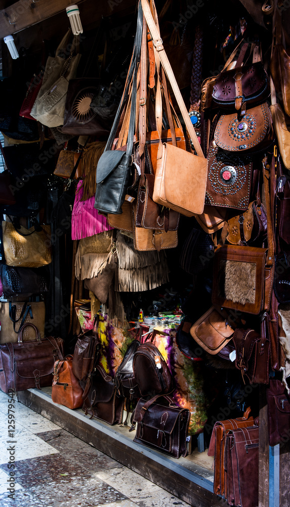 Artisanal craft stall with leather goods in a city, selective focus, city life