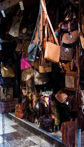Artisanal craft stall with leather goods in a city, selective focus, city life