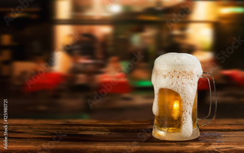cold mug of beer with foam on the background of the street