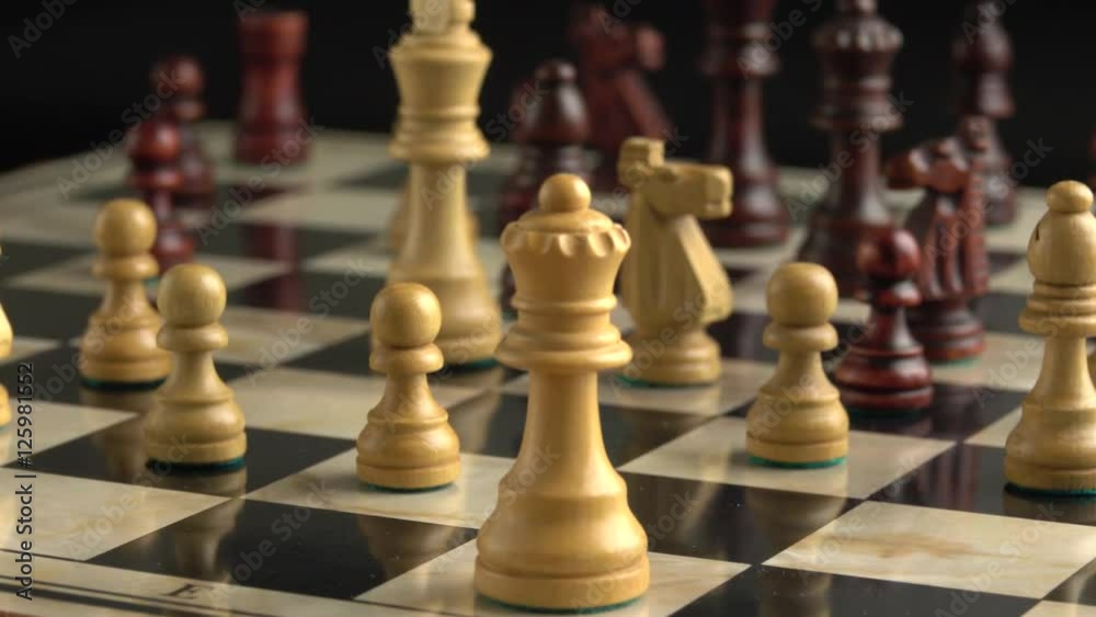 Chess pieces on chessboard with slow sliding motion. Strategy game with two opposing sides fighting for victory. Chess pieces on chessboard with slow sliding motion. Strategy game with two opposing sides fighting for victory.