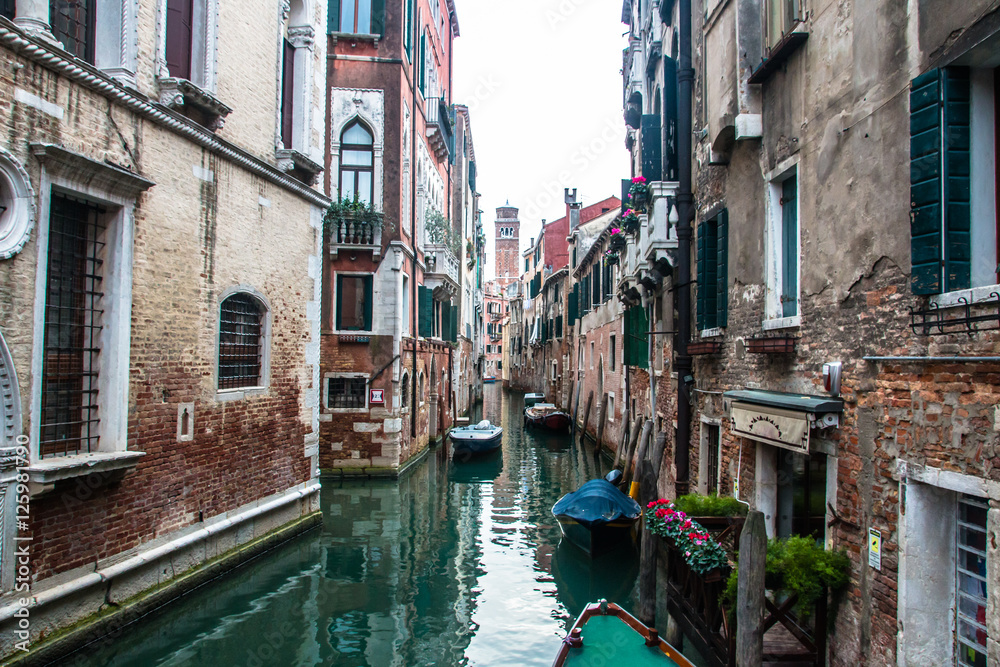 Water canal in venice with boats in Italy
