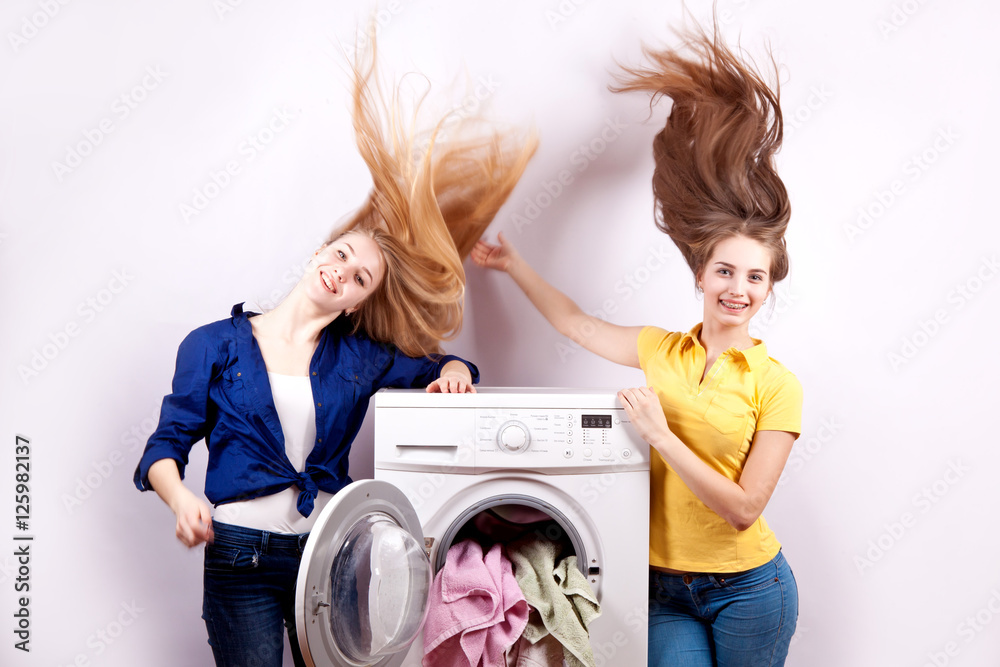 Two girls and a washing machine on  white background