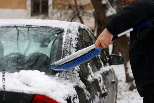 The man who cleans the car from snow.