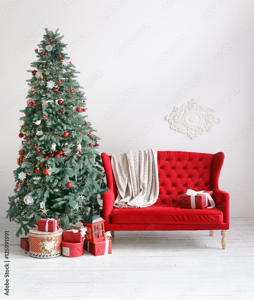 Stylish Christmas interior with an elegant red sofa. Comfort home. Armchair  with fabric upholstery. Christmas tree with presents underneath in living  room Stock Photo | Adobe Stock