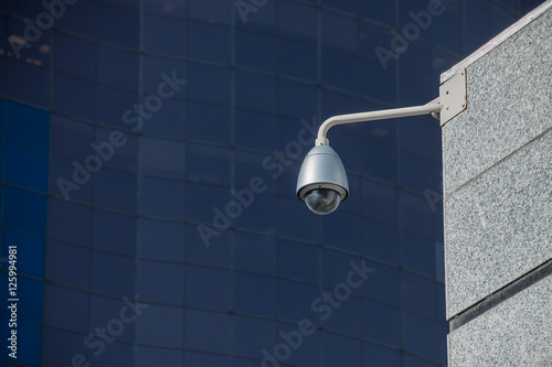Modern security camera over office building background