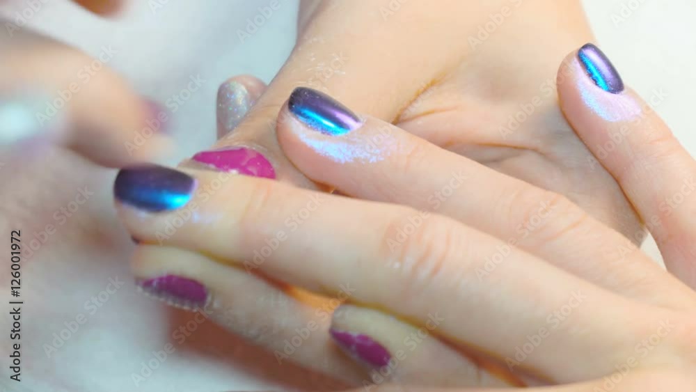 specialist beauty makes a woman a manicure. rubbing shining powder specialist beauty makes a woman a manicure. rubbing shining powder