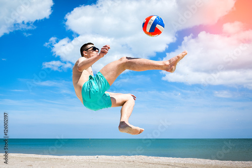 the guy on the beach playing with a ball