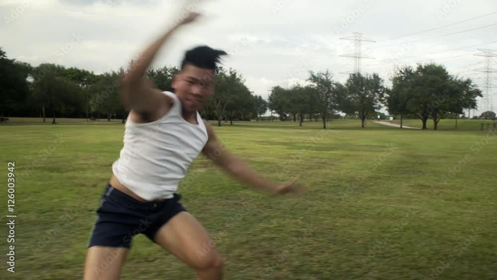 A very fit young Asian man having fun doing cartwheels in the park. A very fit young Asian man having fun doing cartwheels in the park.