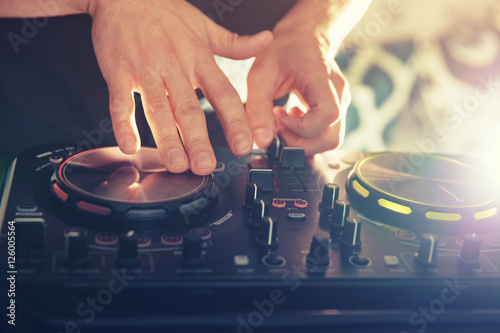 DJ turntable console mixer controlling with two hand in concert nightclub stage.