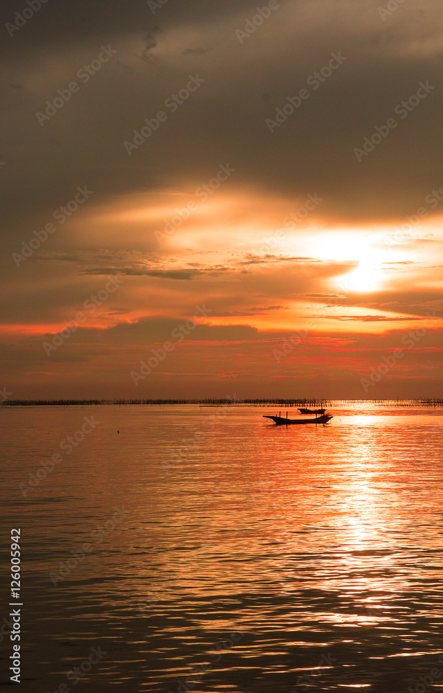 Sea evening sun at sunset. red sunlight sea and the boat Sea evening sun at sunset. red sunlight sea and the boat
