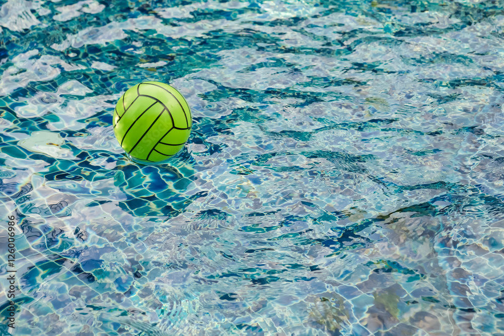 beach ball floating on a sparkling blue swimming pool