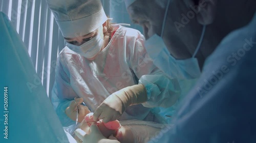 Plastic surgeon wearing sterilized clothing performing reimplantation photo