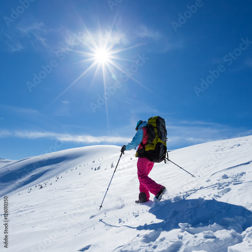 Woman is hiking in snowy winter mountains