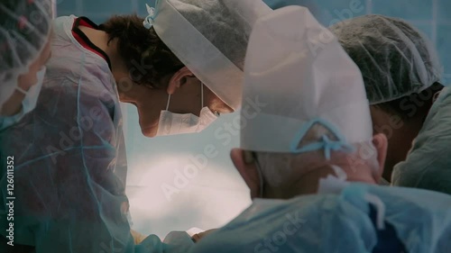 Close-up of medical team in process of performing a surgery in hospital photo
