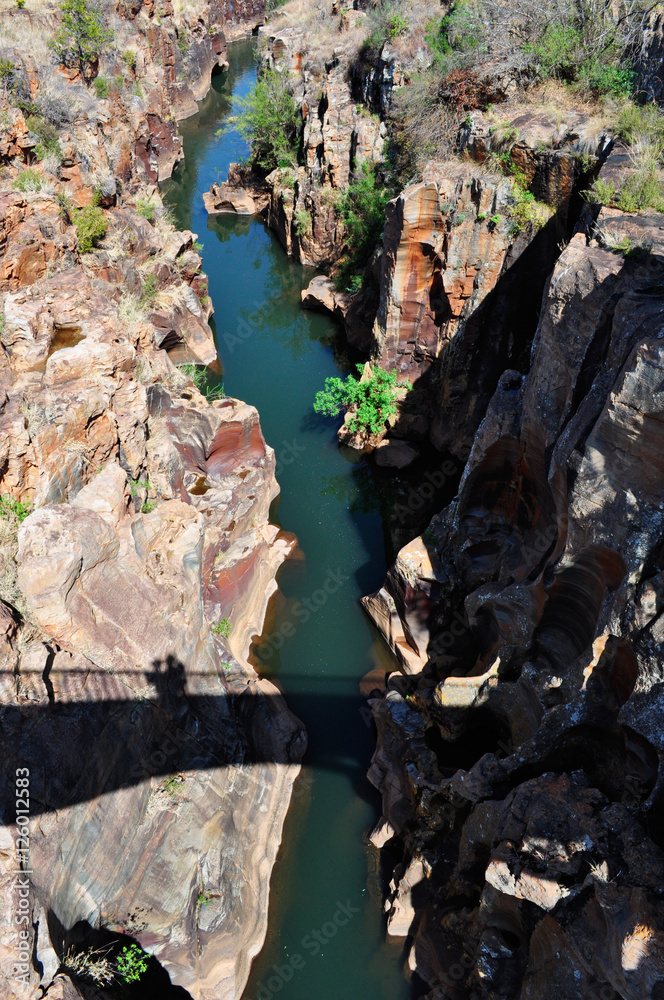 Sud Africa, 01/10/2009: l'ombra del ponte pedonale sul canyon che il fiume Truer forma nelle Bourke's Luck Potholes, una formazione geologica nella riserva naturale del Blyde River Canyon