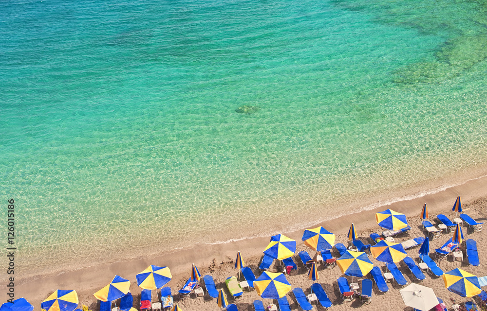 beach with colorful umbrellas and sunbeds and beautiful sea