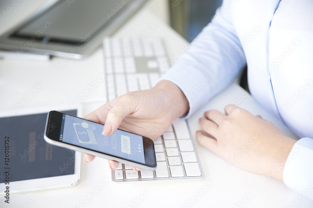 Paying online. Close-up shot of a young businesswoman holding bank card in her hand while using smartphone app to log in her bank account. Paying online. Close-up shot of a young businesswoman holding bank card in her hand while using smartphone app to log in her bank account.