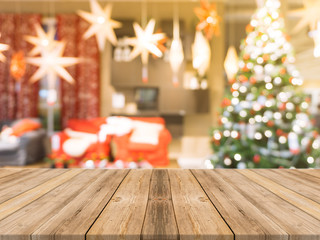 Wooden board empty table top on of blurred background. Perspective brown wood table over blur christmas tree and fireplace background, can be used mock up for montage products display or design layout