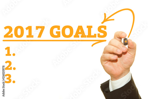 Businessman hand writing 2017 Goals on a transparent wipe board
