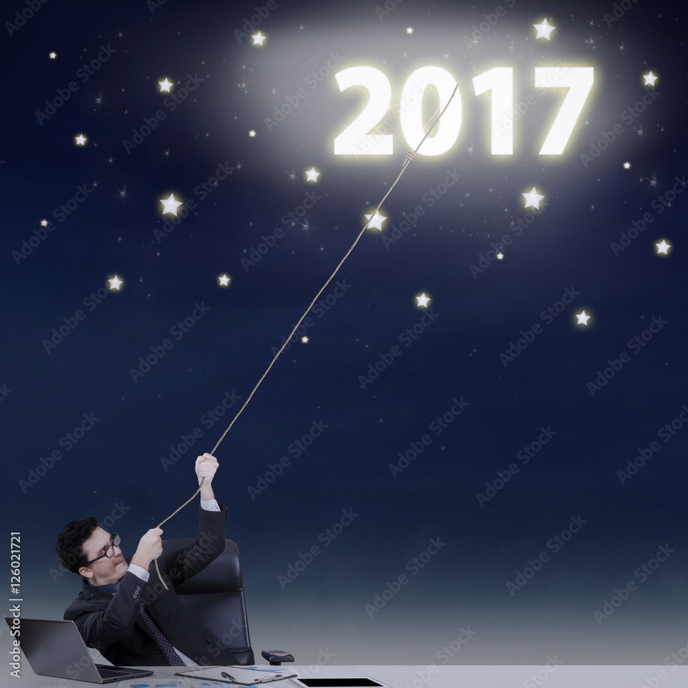 Male worker pulling number 2017 at the sky Male worker pulling number 2017 at the sky