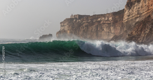Ocean waves and cliffs in Nazare. Autumn day on the Atlantic coast in Portugal.