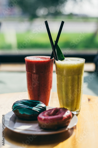 A couple of donuts and a berry smoothie. Rest in a cafe