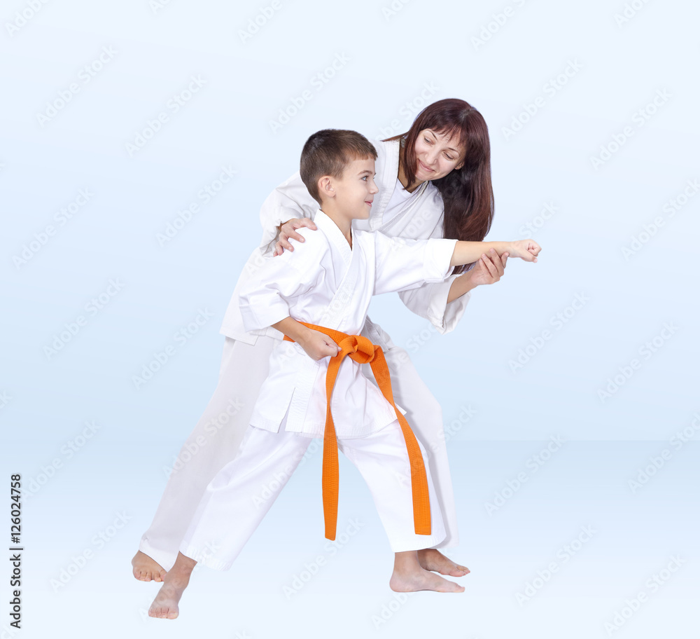 Woman trainer teaches the athlete to hit a punch arm Woman trainer teaches the athlete to hit a punch arm