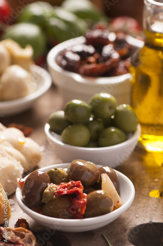 Bread, olives and artichokes served on a wooden table