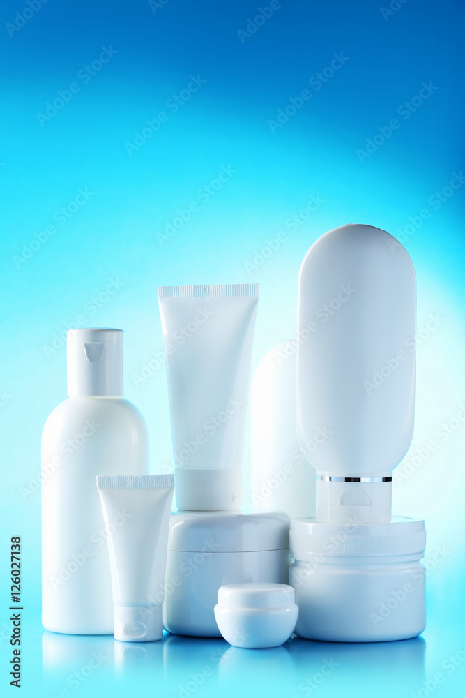 White cosmetic bottles on a blue background White cosmetic bottles on a blue background