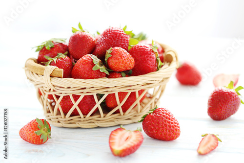 Strawberries in basket on blue wooden table