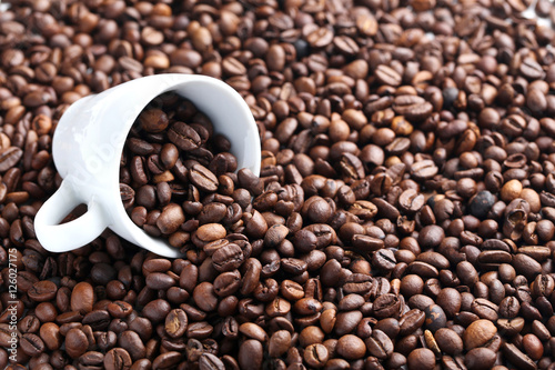 Brown roasted coffee beans in white cup