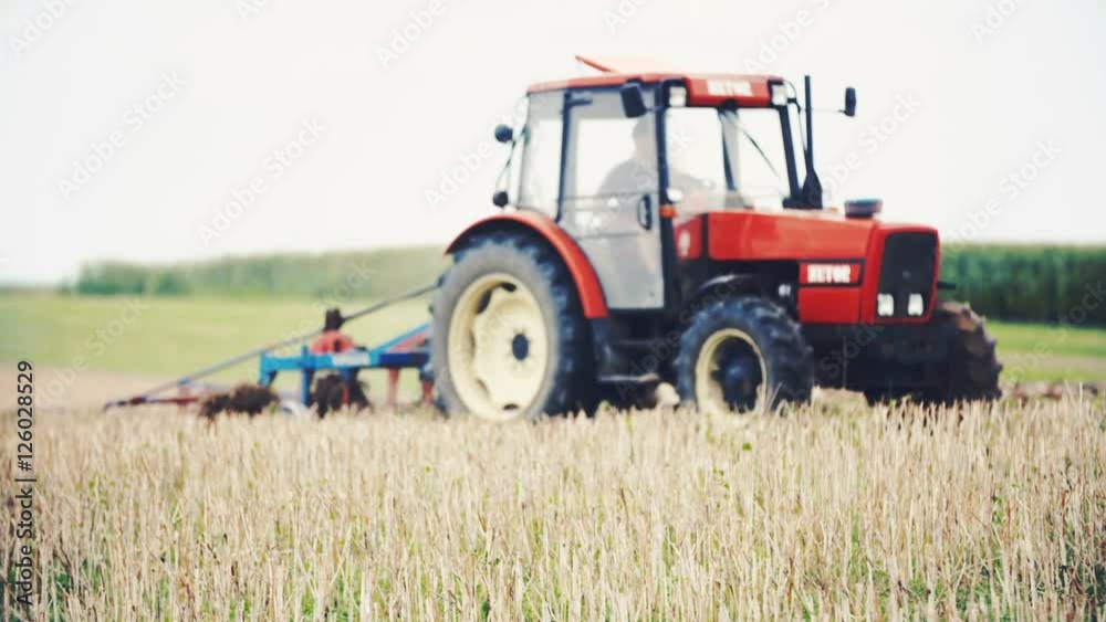 Agricultural tractor sowing and cultivating field Agricultural tractor sowing and cultivating field