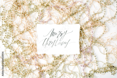 calligraphy words merry christmas and christmas tinsel decoration. flat lay, top view