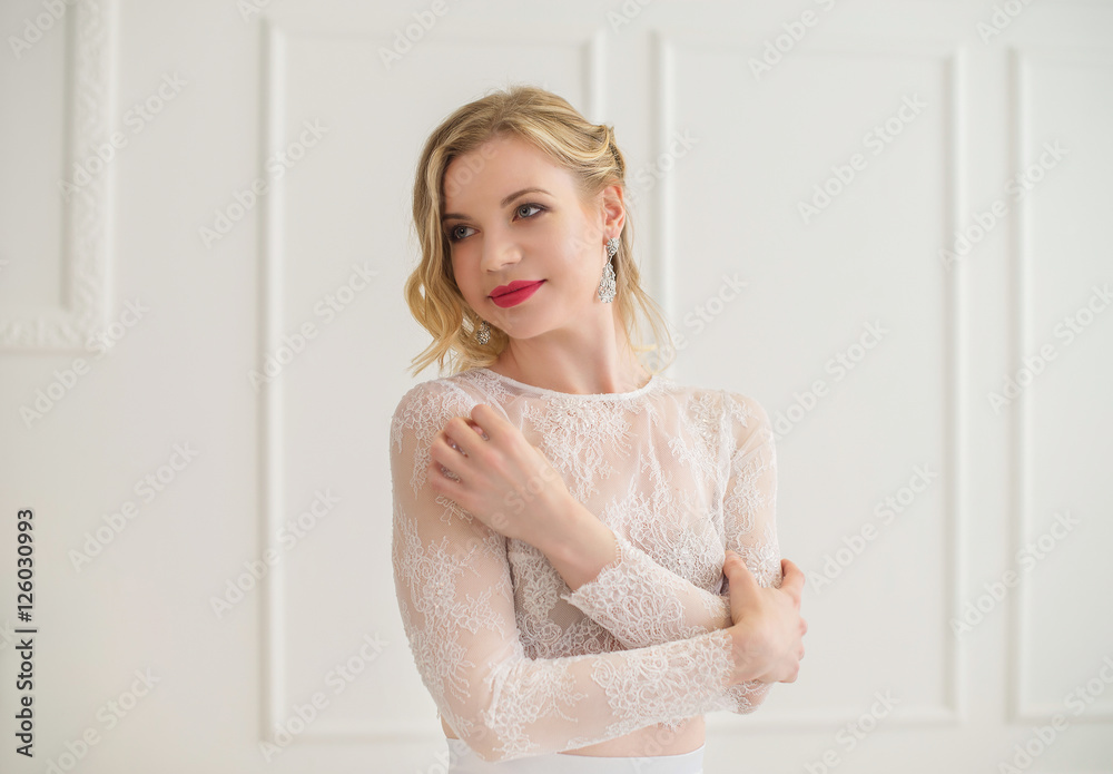 Beautiful bride standing in a white room. Beautiful bride standing in a white room.