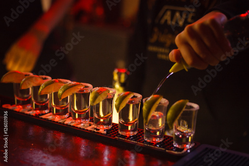 The bartender pours a lot of tequila