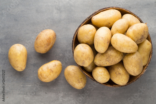 New potato on the bowl  gray background.