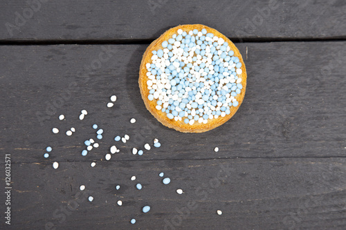 Traditional Dutch birth celebration biscuit with blue muisjes on wooden background