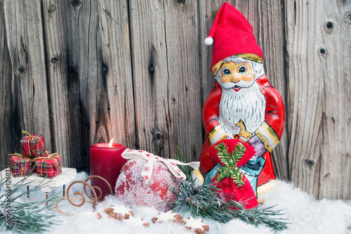 Nikolaus mit Schlitten,Geschenken ,Zimtsternen und Weihnachtsapfel mit Zucker vor Holzhintergrund photo