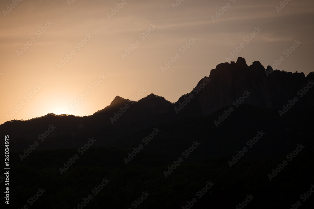 Naklejka premium Sunset and silhouette of mountain peaks at the Bukhansan National Park in Seoul, South Korea. Copy space.