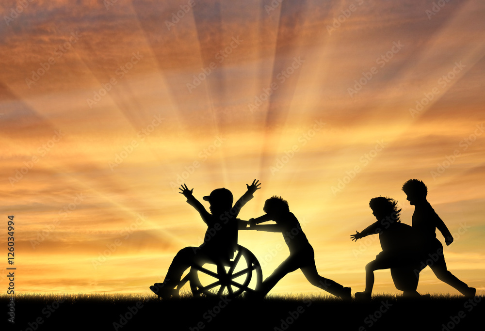 Happy boy in wheelchair playing with children sunset Happy boy in wheelchair playing with children sunset