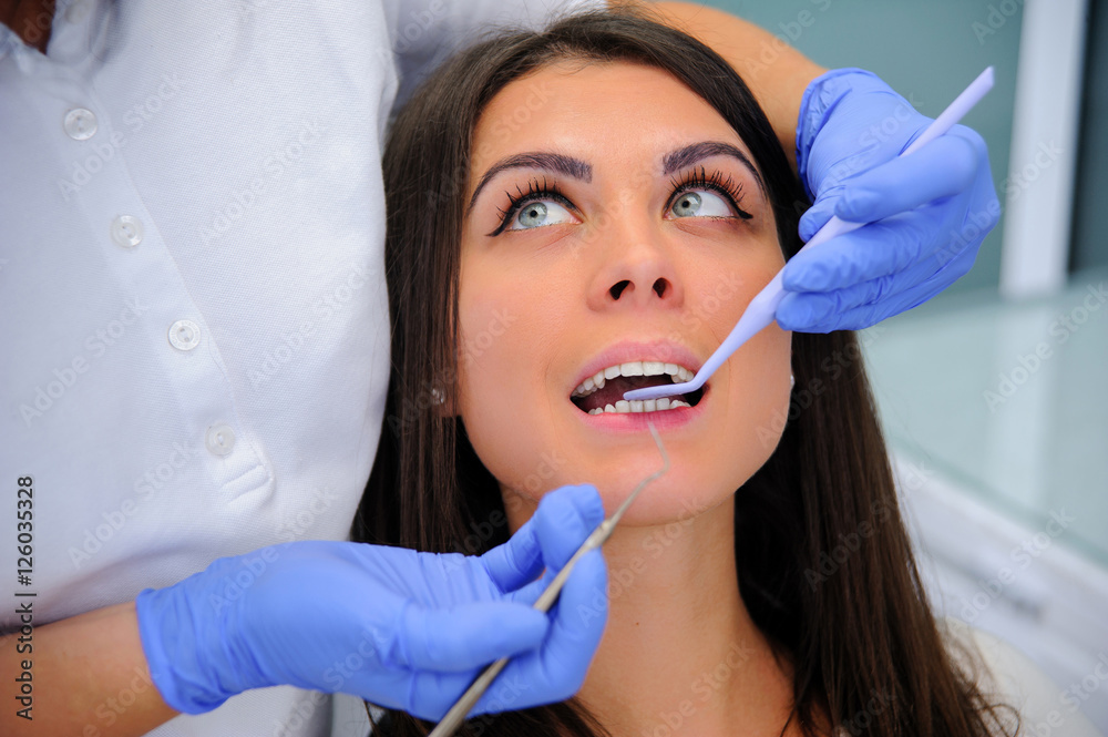 Woman dentist working at her patients teeth