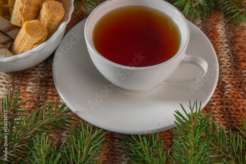 The Christmas tea. A Cup of tea. Christmas decor. In warm tones. Knitted background. Studio light.