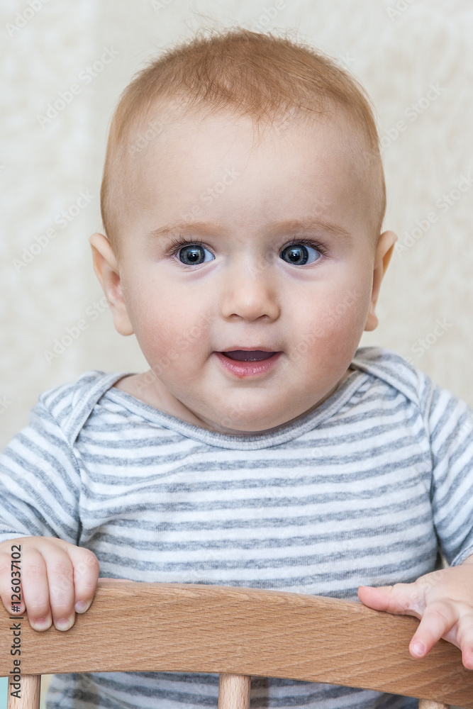 Portrait of happy smiling baby sitting in a cot Portrait of happy smiling baby sitting in a cot