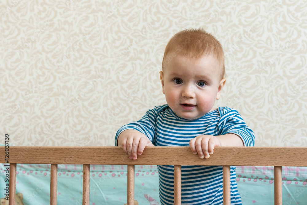 Portrait of happy smiling baby sitting in a cot Portrait of happy smiling baby sitting in a cot