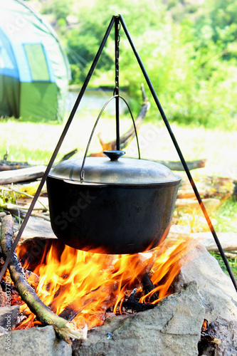 Cooking outdoors. Cauldron on a fire in the forest