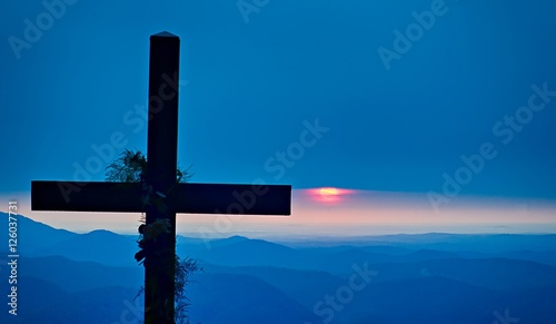 christian worship cross overlooking mountains at sunrise photo