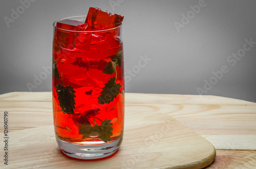 red cocktail with ice/redt cocktail with ice and mint on a wooden table