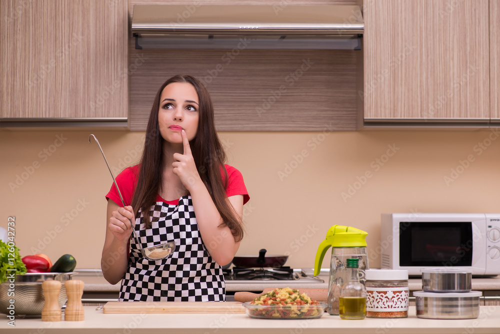 Young woman housewife working in the kitchen Young woman housewife working in the kitchen