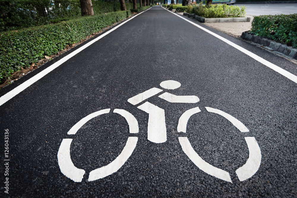 Obraz premium Close up shot of bicycle lane symbol on long asphalt road. Traffic sign