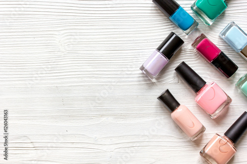 group of nail polish on wooden background top view photo